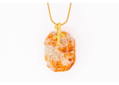 Calcite red orange gemstone pendant on a gold coloured necklace