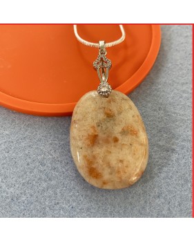 Sunstone cabouchon pendant on a silver coloured necklace