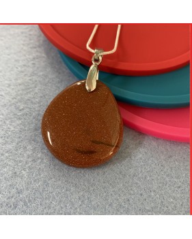 Red Sandstone gemstone pendant on a silver coloured necklace