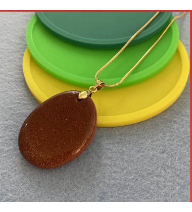 Red Sandstone gemstone pendant on a gold coloured necklace